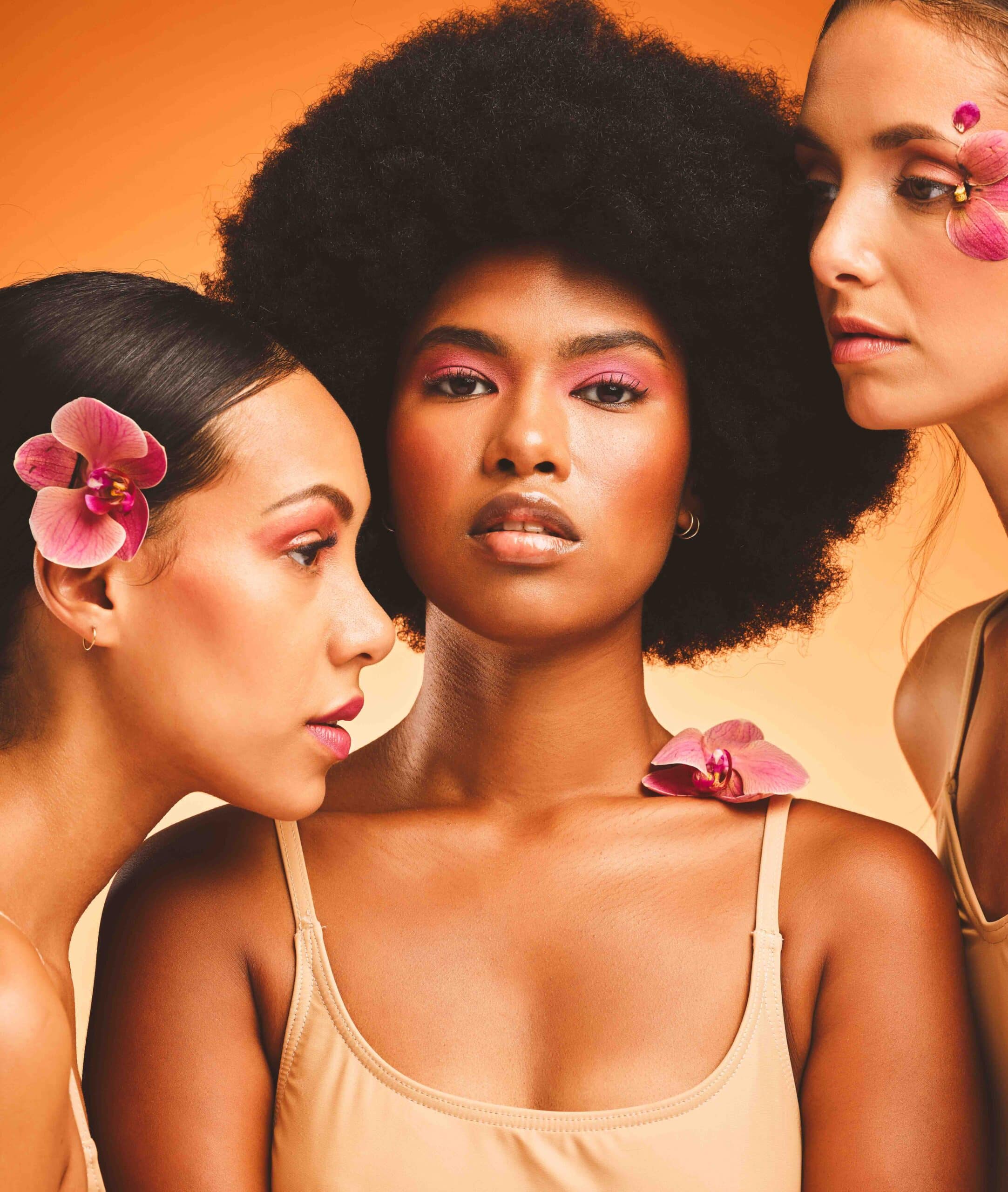 Flowers, beauty and portrait of women with makeup standing in a studio with an orange background. S.