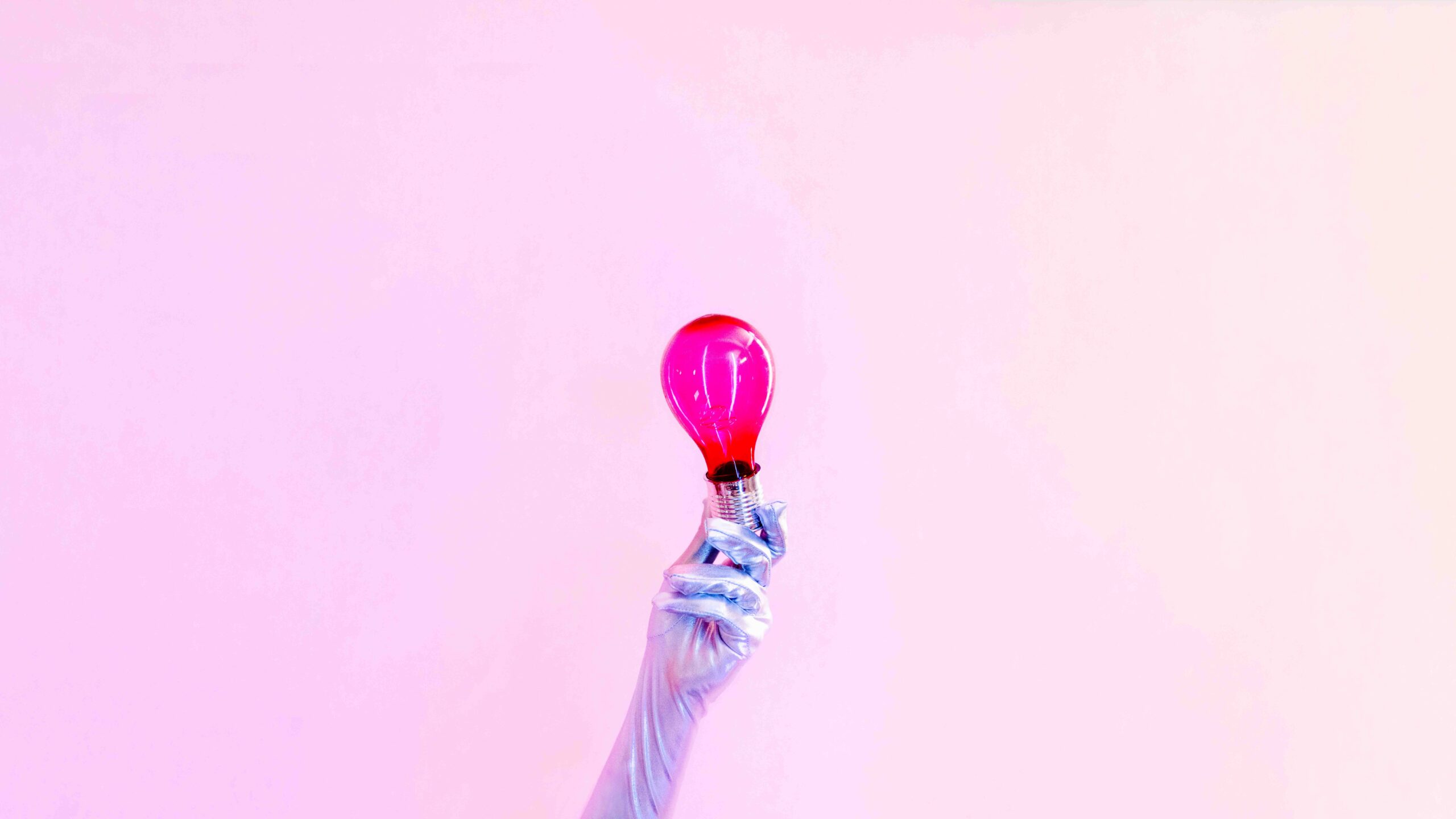 An arm with a glove holding a purple lightbulb