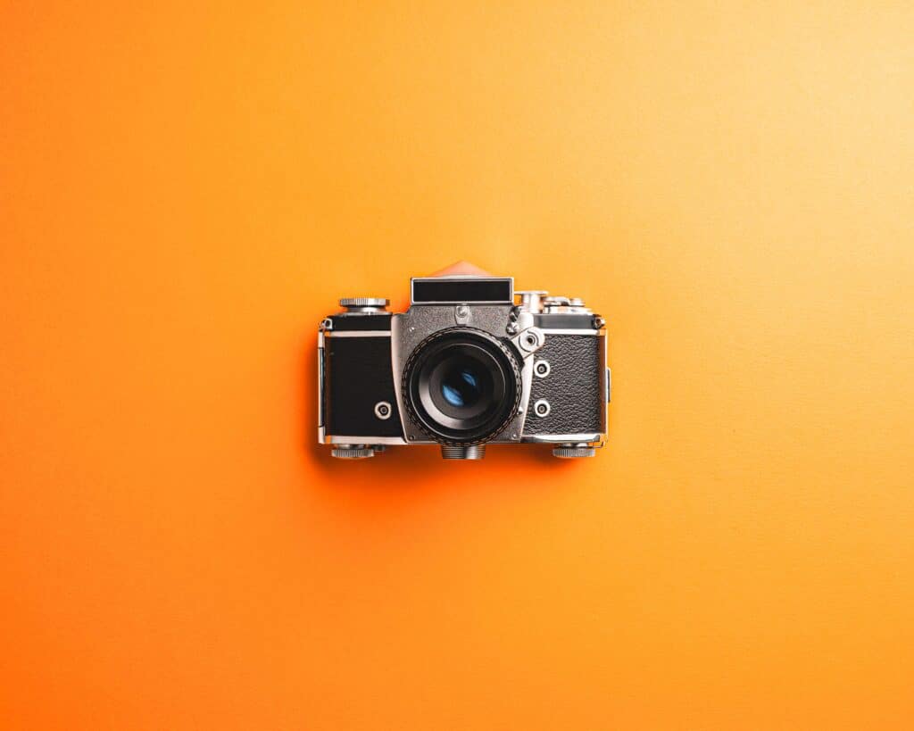 Vintage camera over orange background